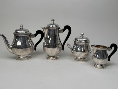 three pieces of silver tea and coffee set on a white surface