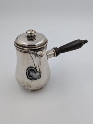une cafetière en argent avec une poignée noire sur un fond blanc
