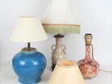 trois vases et une lampe posés sur une table