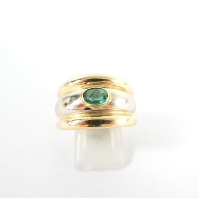a close up of a gold ring with a green stone