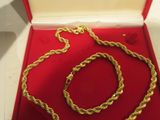 une photo d'un collier et d'un bracelet en or dans un coffret rouge