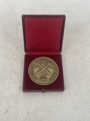 an image of a gold medal in a red box on a white surface