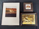 two framed pictures of a farm and a flower are on a table