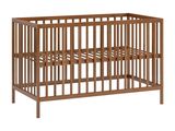 Le lit de bébé est en bois et possède un cadre en métal.