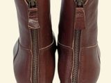 pair of brown leather boots with zippers on a white background