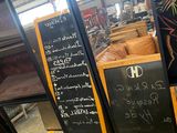 a woman standing in front of a blackboard menu