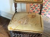 a wooden chair with a seat that has a design on it
