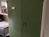 un meuble vert dans un coin de la pièce, sur lequel se trouve un ordinateur