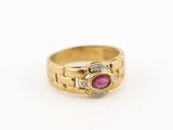 gros plan d'une bague en or avec un rubis et des diamants