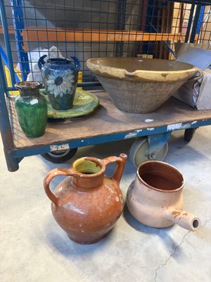 de nombreux vases et bols posés sur une étagère dans une pièce