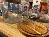 a wooden counter with a glass jar and a wooden cutting board on it