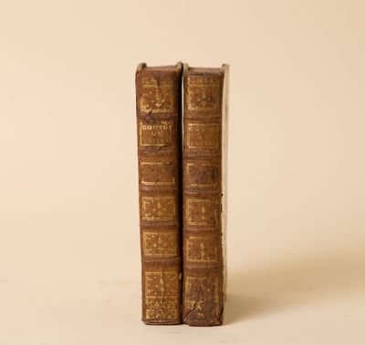 deux vieux livres posés l'un sur l'autre sur une surface blanche