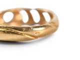 an image of a gold ring on a white surface