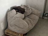 a couch with a blanket on it in the corner of a room