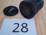 un objectif Canon 28 mm f/1,8 posé sur une table à côté d'un numéro 28
