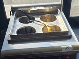 une cuisinière avec deux feux, placée devant une fenêtre
