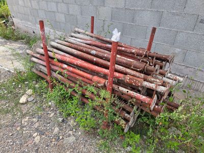 a pile of wood sitting next to a brick wall