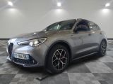 un SUV Alfa gris garé dans un garage au sol carrelé