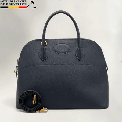 a black leather handbag with gold hardware and a strap