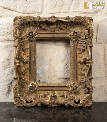 an old picture frame sitting on top of a table next to a brick wall