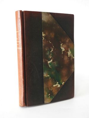 an old book sitting on top of a white table next to a white wall