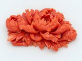 an image of a red flower brooch on a white surface