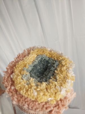 Quelqu'un tient un pot au crochet orné d'un motif au crochet