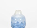 a small blue and white vase on a white surface