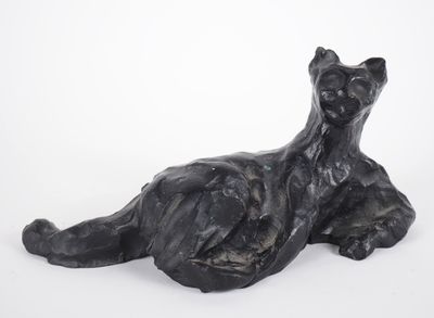 sculpture of a black cat laying down on a white surface