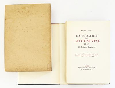 un livre ouvert posé sur une table blanche à côté d'un livre
