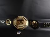 the belt has a gold and black design on it and is attached to a black belt