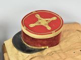 a red hat sitting on top of a pile of tan pants