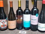 several bottles of wine are lined up in a row on a table