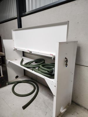 une armoire blanche équipée d'un tuyau, dans une pièce