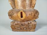 a wooden sculpture of a bird with a hole in it ' s mouth