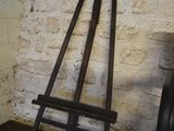 a easel leaning against a brick wall in a room