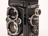 a black and silver camera sitting on a white surface