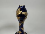 a blue and gold vase sitting on a white surface