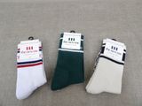 three pairs of white and green socks sitting on top of a couch