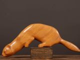 an image of a wooden sculpture of a ferret on a wooden block