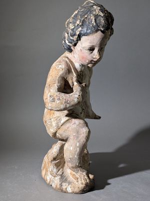 statue d'un garçon tenant un oiseau sur fond gris