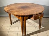 une table en bois avec un tiroir en dessous, posée sur un sol carrelé