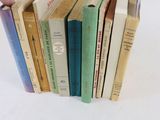 une personne tenant une pile de livres devant un fond blanc