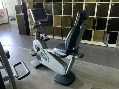 un vélo d'appartement dans une salle de sport, équipé d'un écran à l'arrière