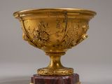 un vase en or posé sur un socle en marbre