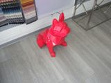 un chien en origami rouge, assis par terre