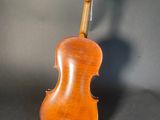 an old violin sitting on top of a black surface