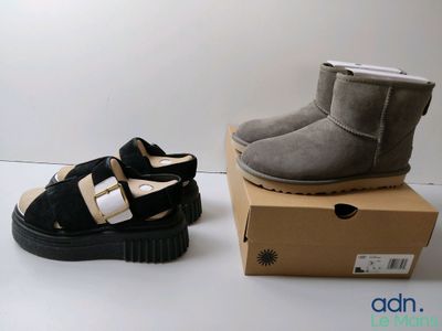 deux paires de chaussures noires et grises posées sur une boîte en carton