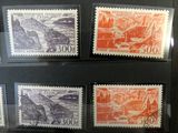 four different stamps are displayed in a display case on a black surface