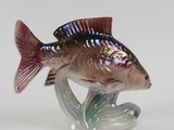 a glass figurine of a fish that is sitting on a stand